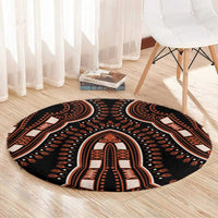 Round black area rug with orange tribal border and central medallion pattern