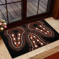 Black rubber doormat with orange and white tribal figure pattern, placed on entry step.