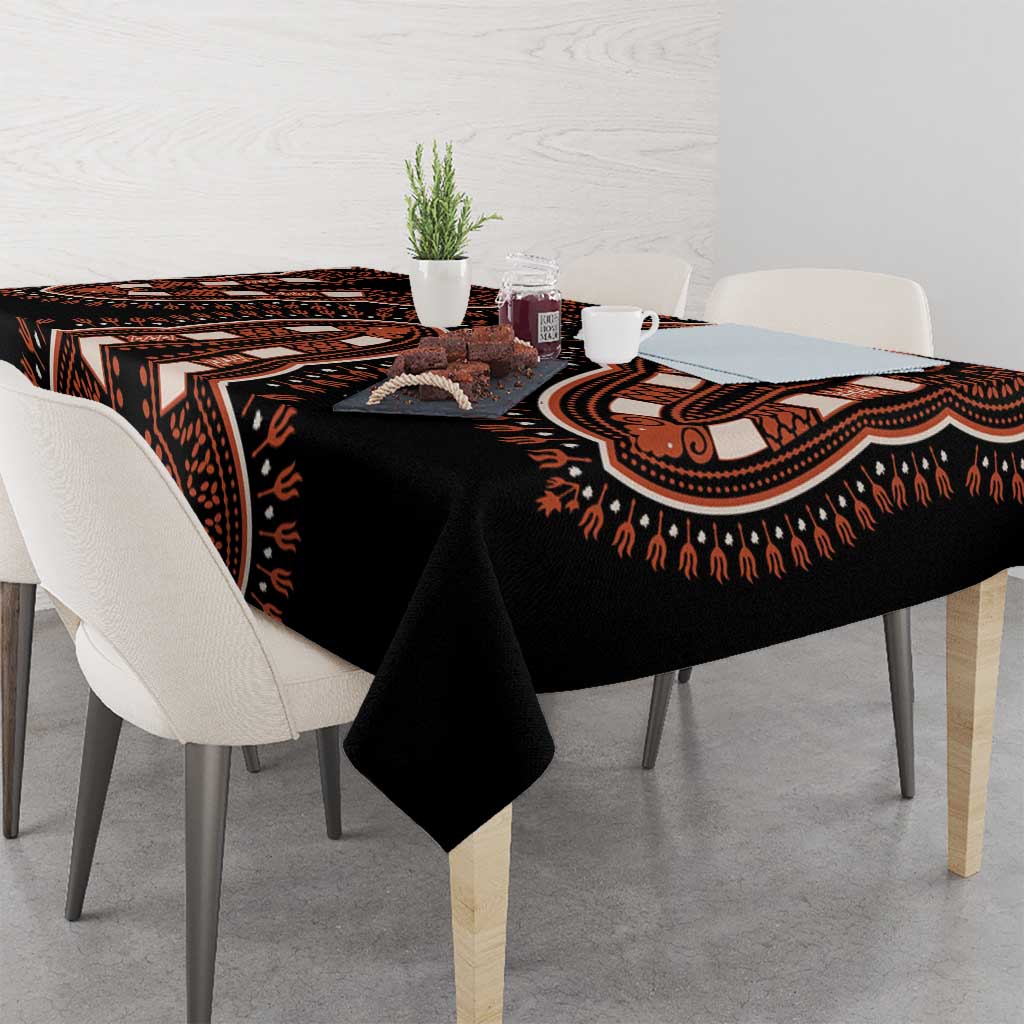 Black tablecloth with bold orange-and-brown dashiki stripe motifs on tabletop