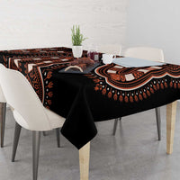 Black tablecloth with bold orange-and-brown dashiki stripe motifs on tabletop