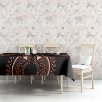 Black tablecloth with orange dashiki motifs, draped over dining table