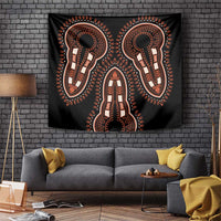 Black wall tapestry with orange ornamental figures and central vertical motif