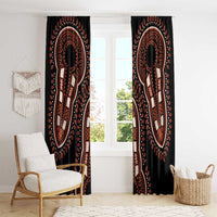 Black dashiki patterned window curtain panels with centered orange figure medallion motifs.
