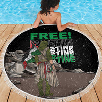 Black round beach blanket with white fringe and central warrior graphic, seen from behind