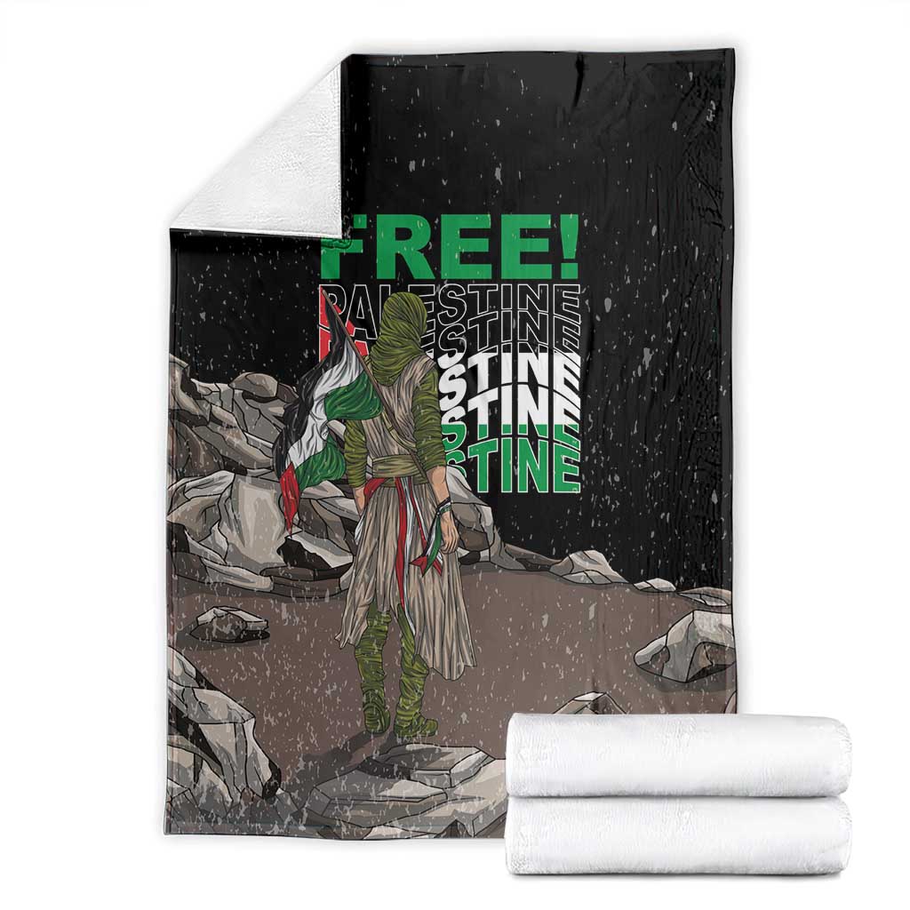 Black throw blanket with green 'FREE' and 'PALESTINE' text, with rolled white towels
