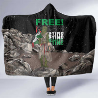 Black hooded blanket with large “FREE!” graphic and illustrated scene on front panel
