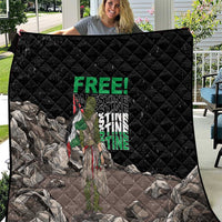 Black quilt with diamond stitching and Palestine-themed graphic, shown laid out outdoors