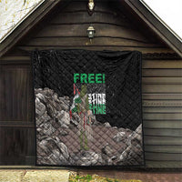 Black quilt with diamond stitching and Palestine-themed graphic hanging in a barn doorway