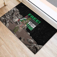 Black rubber doormat with standing eagle and “FREE” “PALESTINE” text over rocks