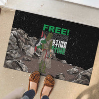 Black rubber doormat with eagle graphic and “FREE” “PALESTINE” text, shown with shoes