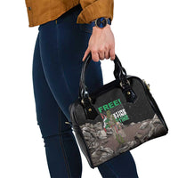 Black shoulder handbag in hand, top handles and printed front panel
