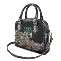 Black handbag with glossy finish, top handles and crossbody strap, front graphic