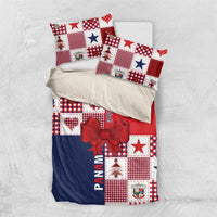 Christmas bedding set folded on bed: red and navy patchwork with stars, trees, and ribbon bow