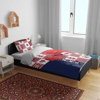 Christmas bedding set on bed with white, red, and navy patchwork design, bow detail