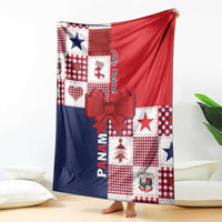 Christmas throw blanket folded with red top, navy bottom, patchwork blocks, and red bow detail.