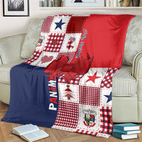 Christmas throw blanket draped on a sofa, red and navy patchwork with checkered squares and bow.
