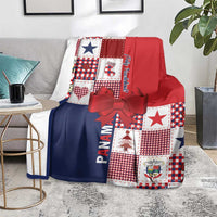 Christmas blanket on a sofa with red and navy patchwork design, checkers, and red bow ribbon.