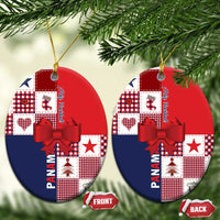 Two red and navy ceramic oval ornaments with patchwork graphics, red bow, and gold cord