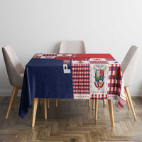 Patchwork tablecloth in red, white, and navy covering dining table with chairs