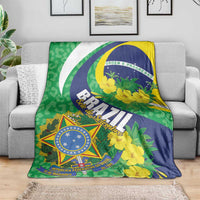 Brazil-themed floral throw blanket on couch, green blue yellow with shield emblem
