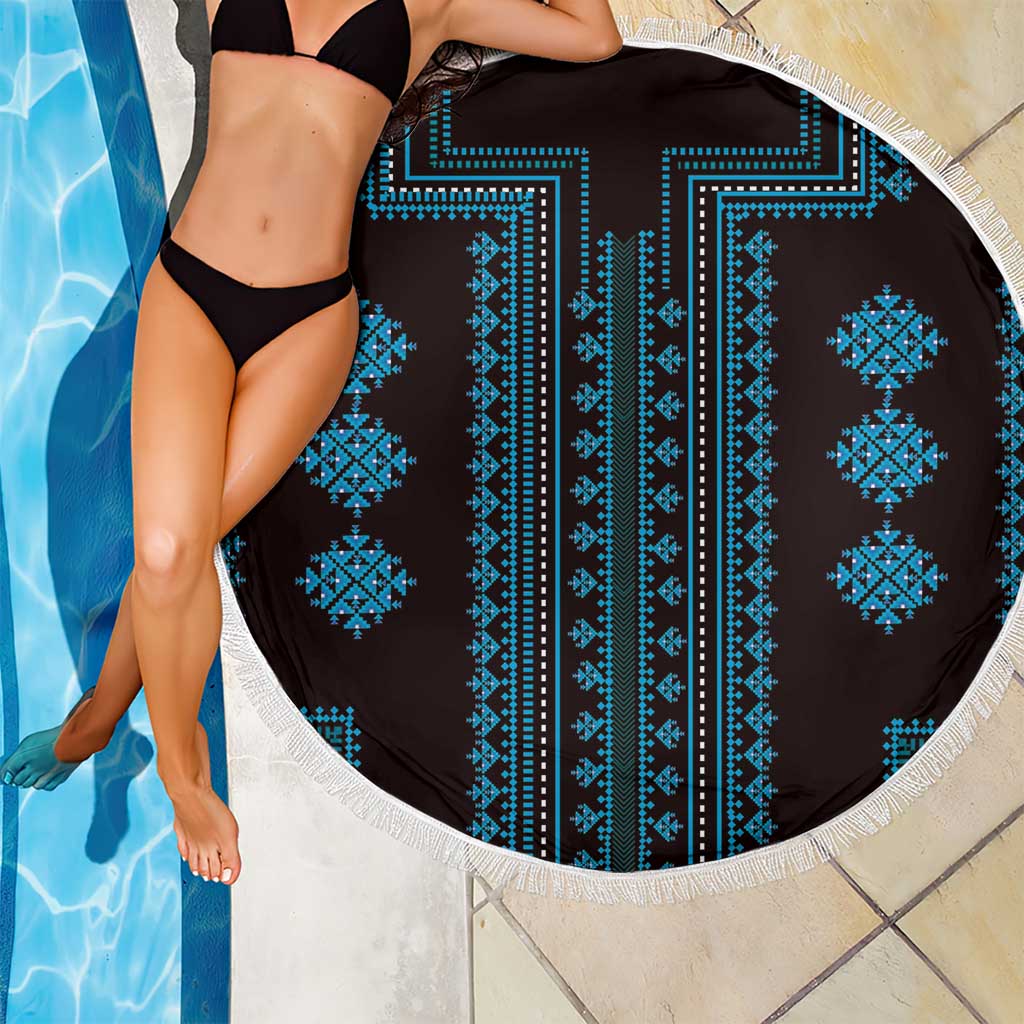 Round blue patterned beach blanket with white fringe, draped on a bather