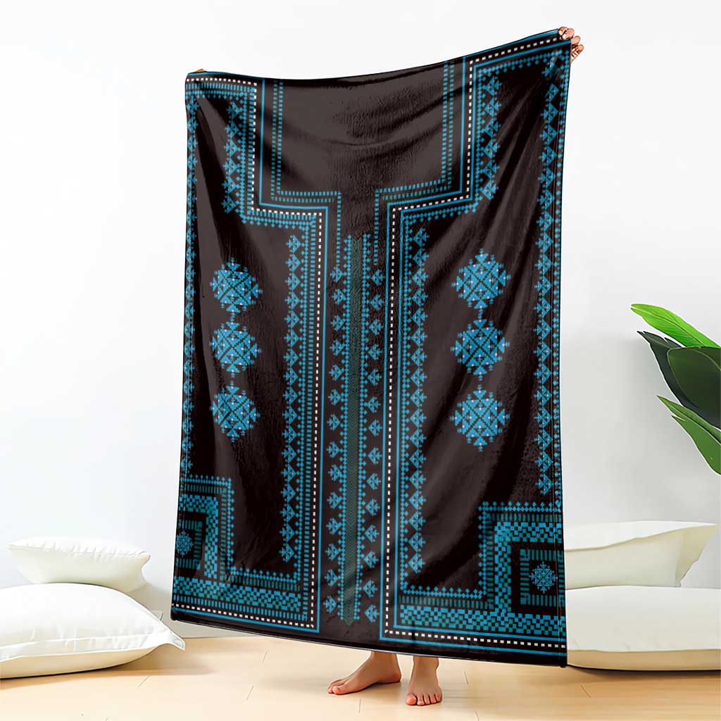 Traditional blanket draped with dark fabric and bright blue geometric pattern panels