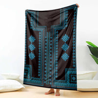 Traditional blanket draped with dark fabric and bright blue geometric pattern panels