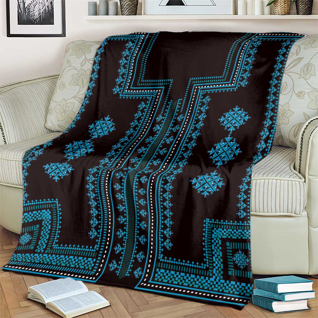 Traditional pattern blanket in dark fabric with vivid blue zigzag and diamond motifs