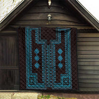 Dark quilt blanket with blue geometric border and star-like diamond motifs