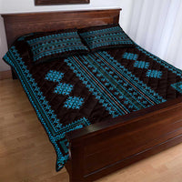 Blue and black geometric quilt and pillow shams on a bed