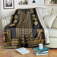 Dark gold-trimmed blanket draped over sofa with geometric vertical stripe design