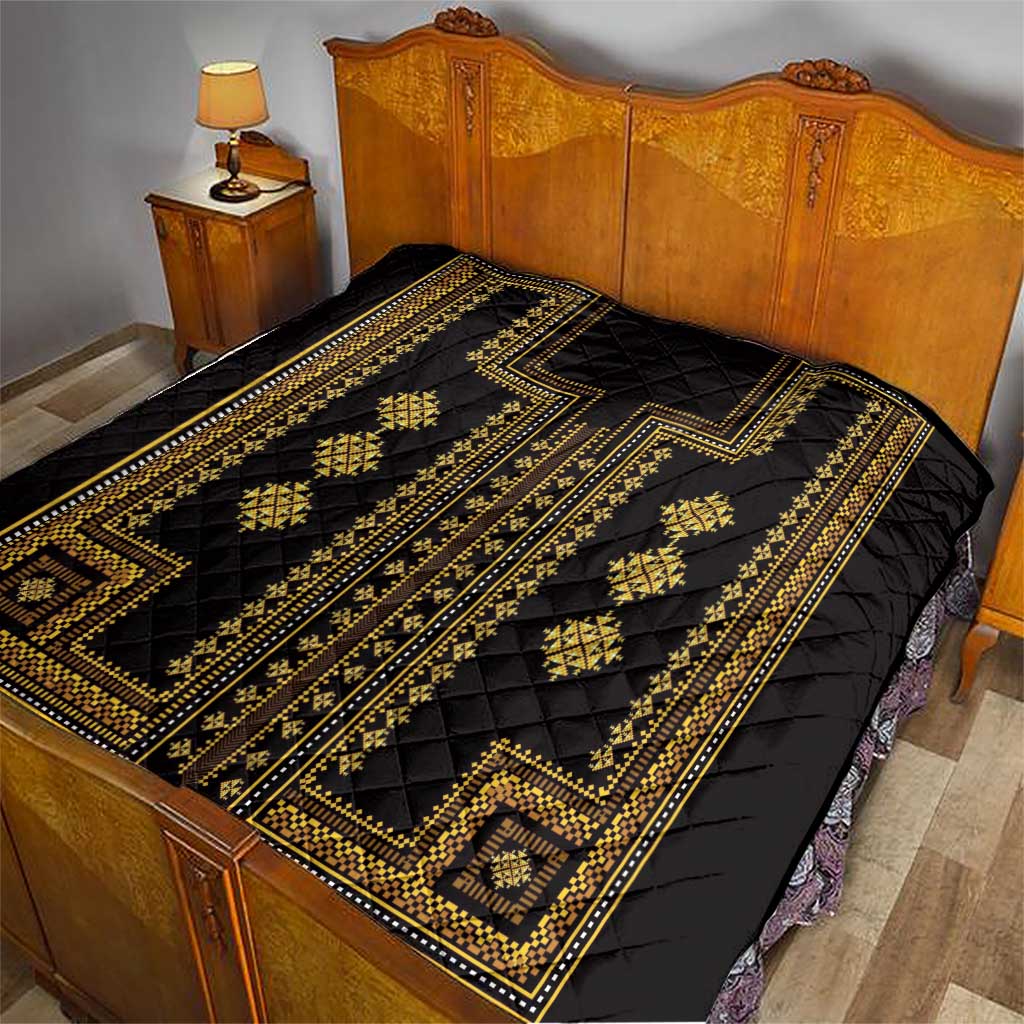Black quilt on bed with gold geometric centerpiece, borders, and repeating diamond motifs.