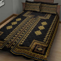 Black quilt with gold stripe and geometric motifs, paired with two pillow shams