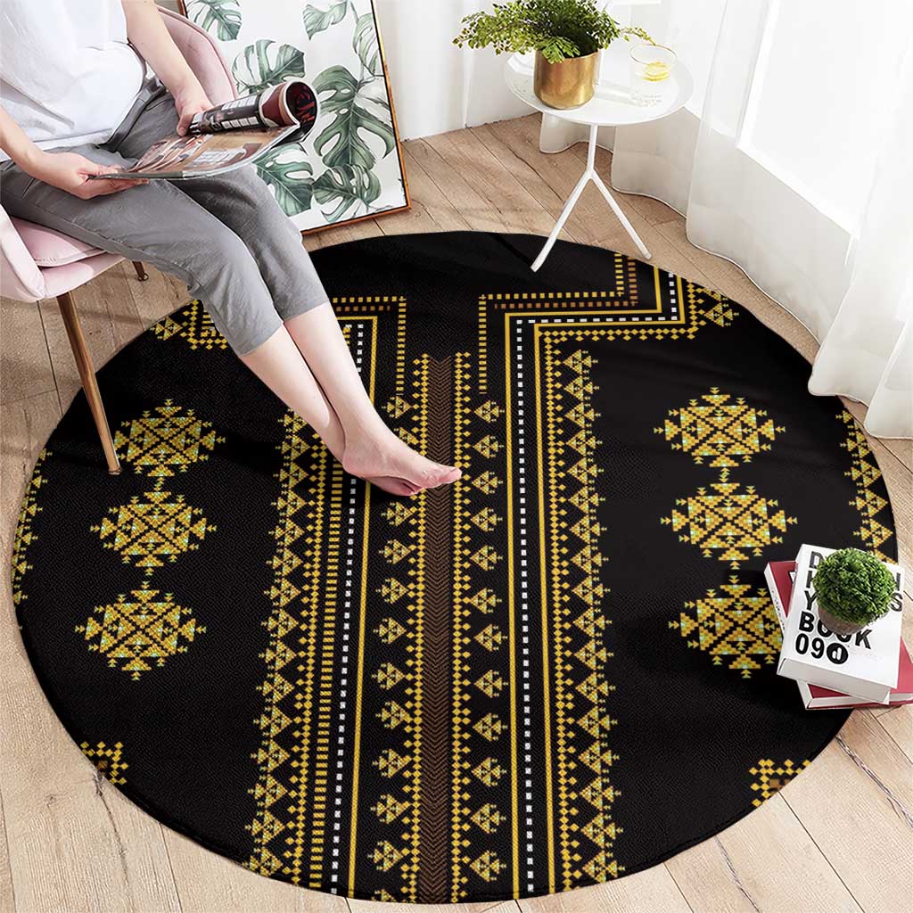 Round black rug with gold geometric bands, medallions, and a long vertical stripe.