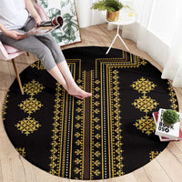 Round black rug with gold geometric bands, medallions, and a long vertical stripe.