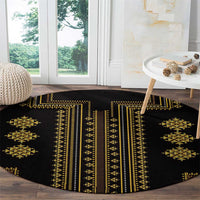 Round black rug with gold geometric motifs and striped center design.