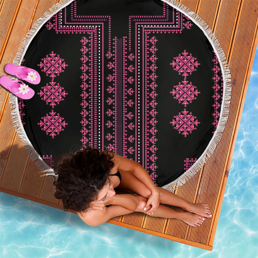 Round beach blanket with black base, pink cross-stitch diamonds, and white fringe border