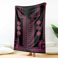Black and pink patterned throw blanket with diamond motifs, draped over corner