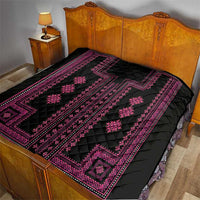 Black quilt with vivid pink embroidery-style lines and diamond shapes, quilted.