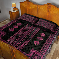 Black quilt and pillow shams with vivid pink geometric trim pattern on a bed