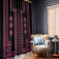 Black window curtain with pink traditional geometric design panel, hanging beside a chair.