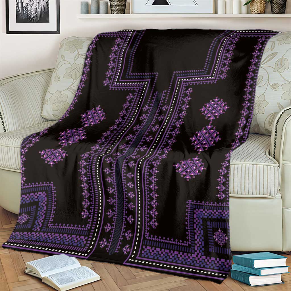 Black and purple geometric throw blanket with diamond motifs, spread on couch