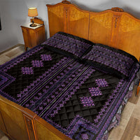 Purple and black quilt bed set with two patterned pillows on a wooden bed