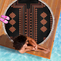 Round beach blanket with black fabric, red border medallions, and white tassel fringe