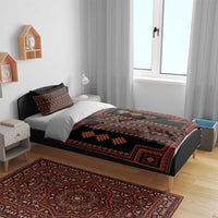 Black duvet and pillow shams with red geometric Balkan motif, laid on bed