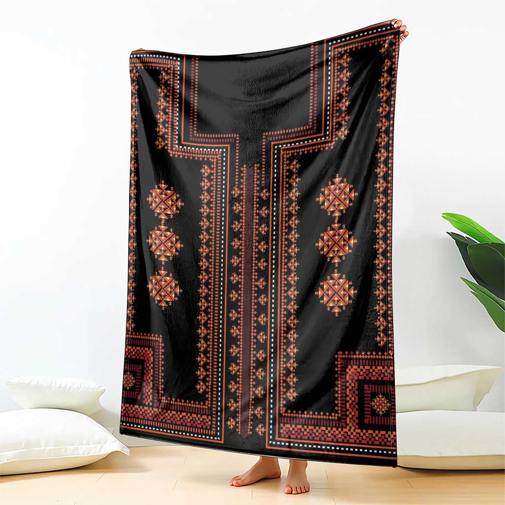 Black woven blanket with bold vertical geometric motifs and orange-red accents, draped