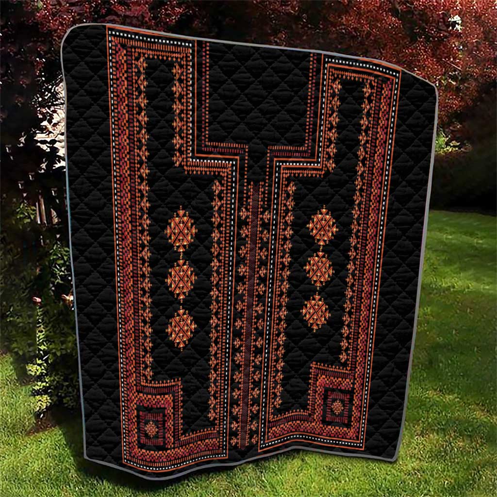 Black quilt with red geometric ornament panels and diamond medallion details on top.