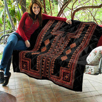 Black quilt featuring red geometric border, diamond motifs, and central patterned panels.