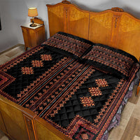 Black quilt bed set with red patterned bands and diamond medallions, shown on bed