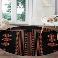 Round rug on wood floor with black base and red geometric panel motifs